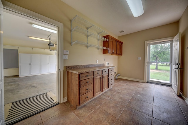 kitchen featuring brown cabinetry, baseboards, and visible vents