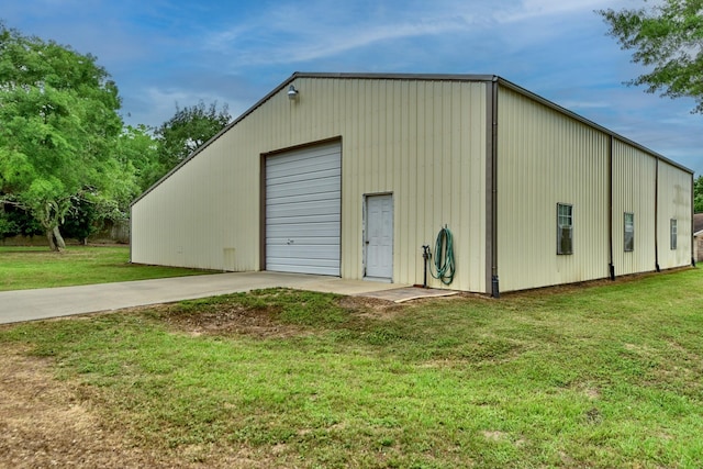 view of outdoor structure featuring an outbuilding and concrete driveway