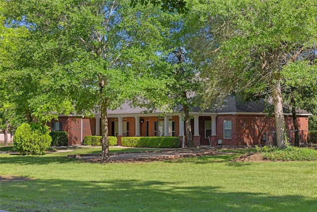 324 Howard St, Sealy, TX 77474 - view of front of home with a front yard, brick siding, and a porch