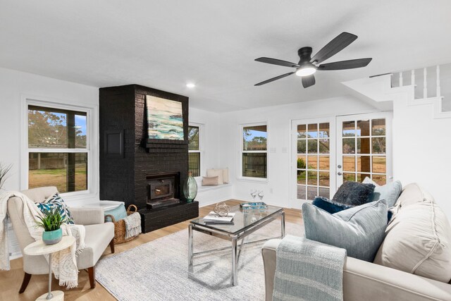 living area featuring a fireplace, french doors, wood finished floors, and plenty of natural light