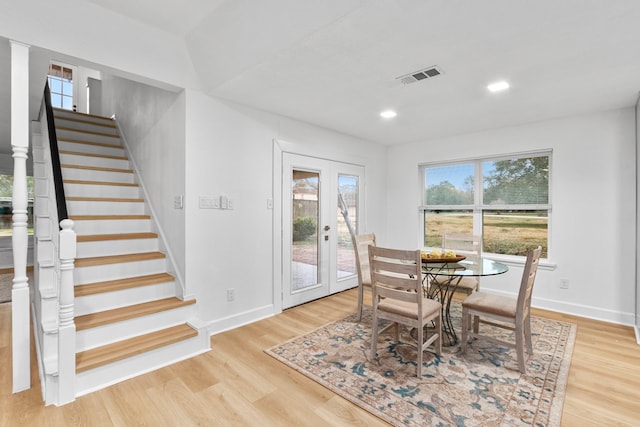 dining room featuring stairway, visible vents, light wood finished floors, and baseboards