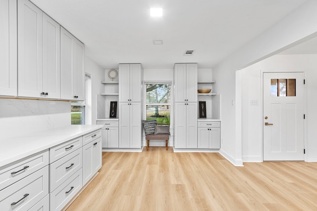 kitchen featuring open shelves, visible vents, and light wood-style floors