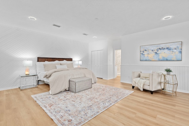 bedroom featuring baseboards, visible vents, light wood-style floors, and a closet