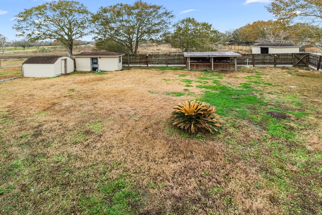 view of yard with a fenced backyard, an outbuilding, and a storage shed