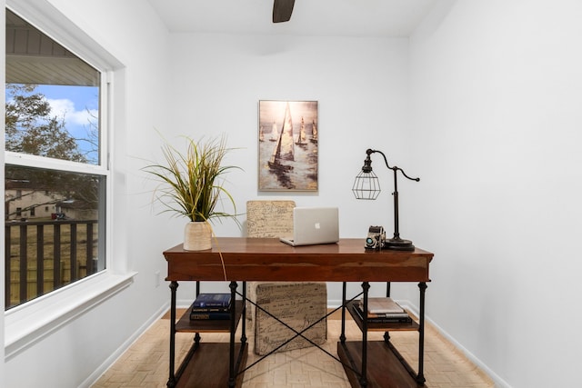 office space featuring a ceiling fan, baseboards, and a healthy amount of sunlight