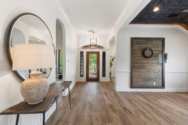 foyer entrance featuring crown molding, baseboards, and wood finished floors