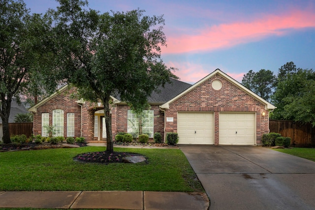 ranch-style house featuring fence, an attached garage, a front lawn, brick siding, and driveway