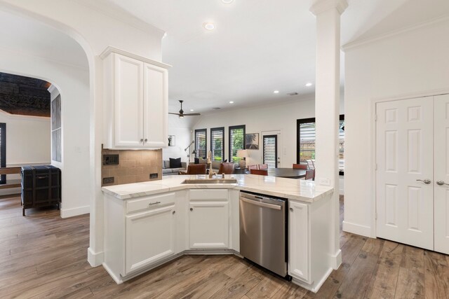 kitchen with crown molding, open floor plan, a sink, and dishwasher