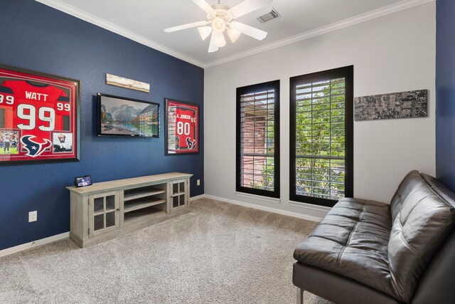living area featuring carpet floors, a ceiling fan, baseboards, and ornamental molding