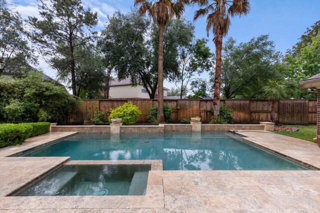 view of swimming pool featuring a fenced backyard and a pool with connected hot tub