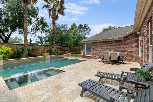 view of pool featuring outdoor dining area, a fenced backyard, a patio area, and a pool with connected hot tub