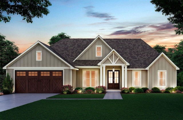 view of front facade featuring a shingled roof, driveway, a front yard, and a garage