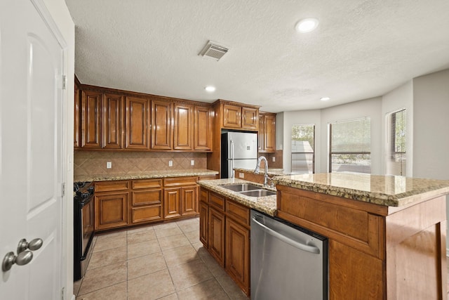 2905 Baer St Unit 3, Houston, TX 77020 - kitchen featuring brown cabinets, visible vents, a sink, tasteful backsplash, and appliances with stainless steel finishes