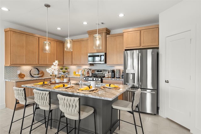158 W Coralburst Loop, Montgomery, TX 77316 - kitchen featuring decorative backsplash, a breakfast bar, light tile patterned floors, stainless steel appliances, and light stone countertops