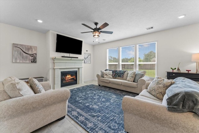 8804 Ute Creek Ln, Magnolia, TX 77354 - living area with recessed lighting, ceiling fan, a glass covered fireplace, visible vents, and a textured ceiling