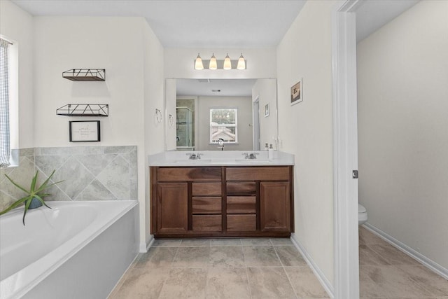 8804 Ute Creek Ln, Magnolia, TX 77354 - bathroom with a shower stall, a sink, double vanity, toilet, and a garden tub