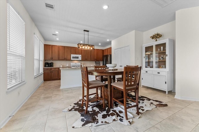 8804 Ute Creek Ln, Magnolia, TX 77354 - dining space featuring light tile patterned floors, recessed lighting, visible vents, and baseboards