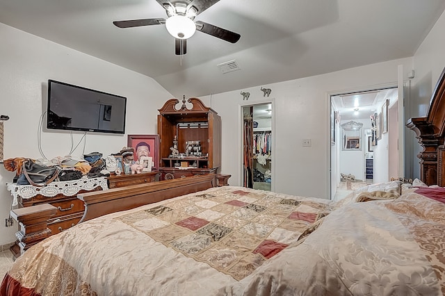 bedroom with attic access, vaulted ceiling, visible vents, a closet, and a walk in closet