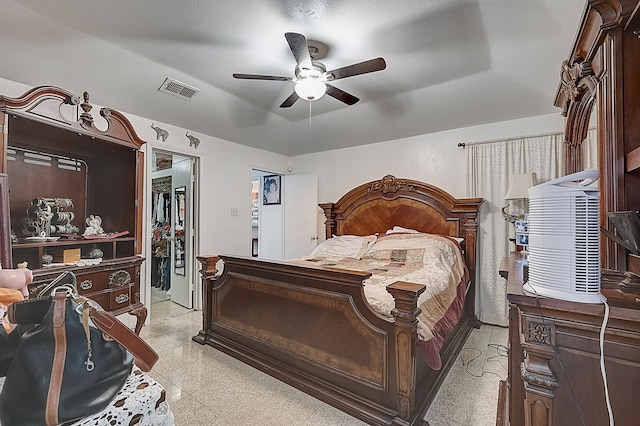 bedroom featuring a tray ceiling, visible vents, a spacious closet, a ceiling fan, and a closet