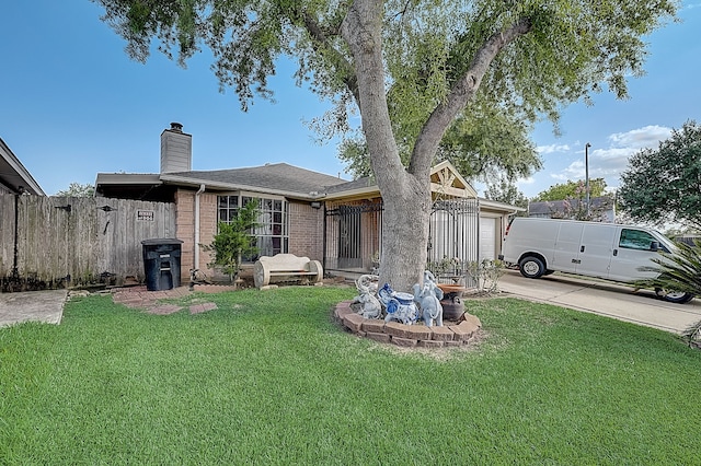 exterior space with a chimney, fence, an attached garage, brick siding, and a front yard