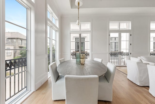 dining space with light wood-style flooring and a decorative wall