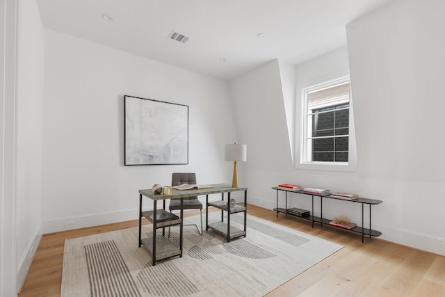 office featuring light wood-style floors, visible vents, and baseboards