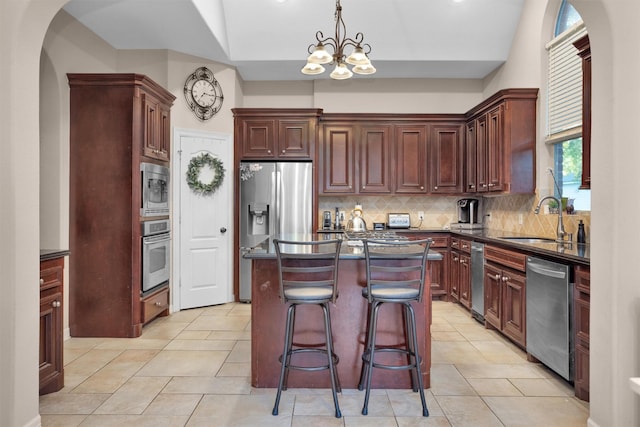11409 E Zoe Loop Dr, Montgomery, TX 77316 - kitchen with appliances with stainless steel finishes, dark countertops, arched walkways, tasteful backsplash, and a sink