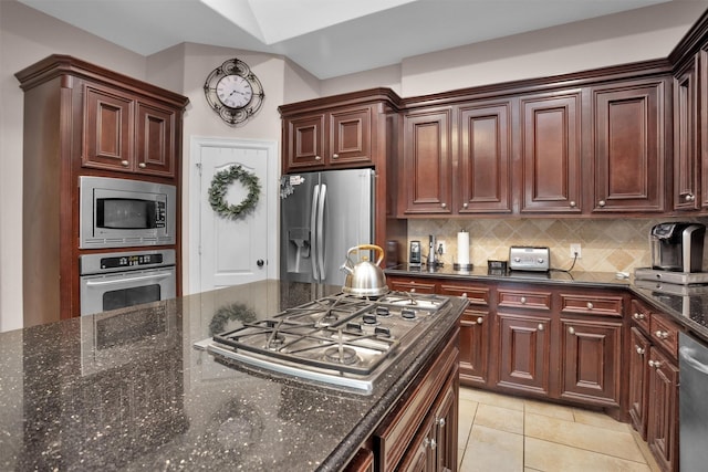 11409 E Zoe Loop Dr, Montgomery, TX 77316 - kitchen featuring stainless steel appliances, backsplash, dark stone countertops, and light tile patterned floors
