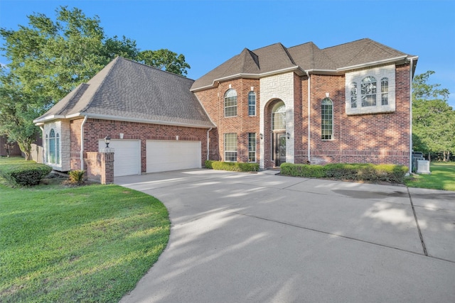 11409 E Zoe Loop Dr, Montgomery, TX 77316 - view of front facade with brick siding, a garage, a front yard, concrete driveway, and roof with shingles