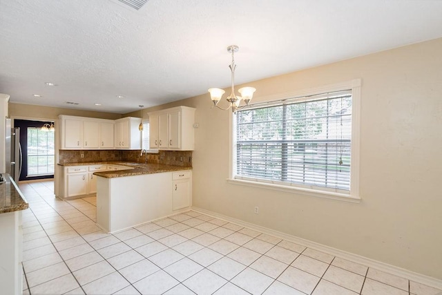 1103 Suwanee Ln, Houston, TX 77090 - kitchen with a wealth of natural light, a notable chandelier, tasteful backsplash, and white cabinetry