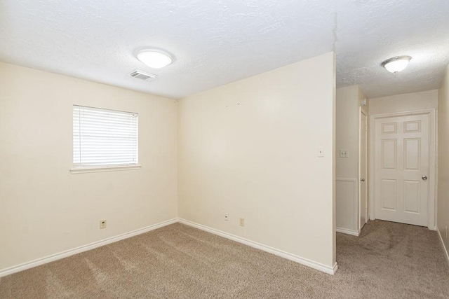 1103 Suwanee Ln, Houston, TX 77090 - spare room featuring visible vents, baseboards, a textured ceiling, and light colored carpet