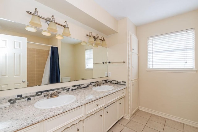 1103 Suwanee Ln, Houston, TX 77090 - bathroom with baseboards, tile patterned floors, a sink, and double vanity