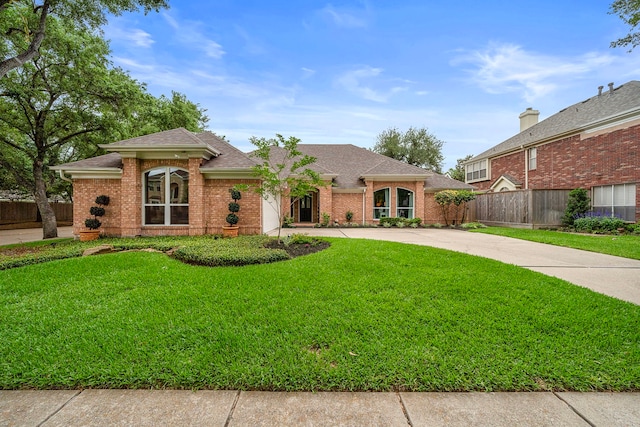 ranch-style home featuring roof with shingles, driveway, and a front lawn
