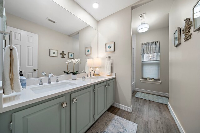 bathroom with visible vents, a sink, and wood finished floors