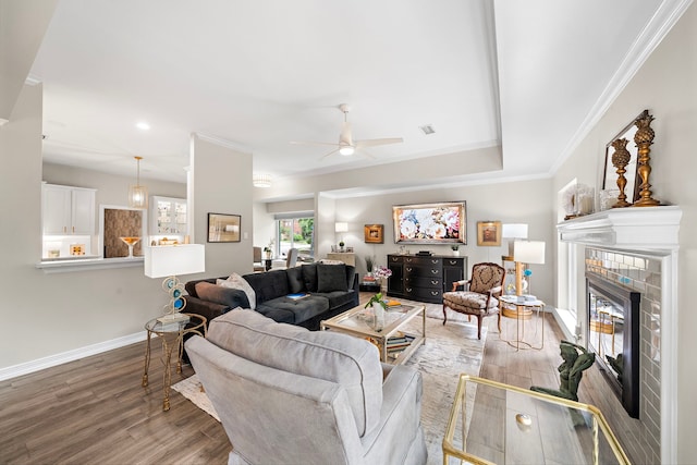 living room featuring baseboards, ceiling fan, crown molding, and wood finished floors