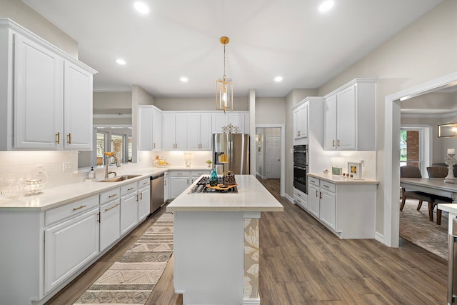 kitchen featuring a sink, appliances with stainless steel finishes, a kitchen island, and a wealth of natural light