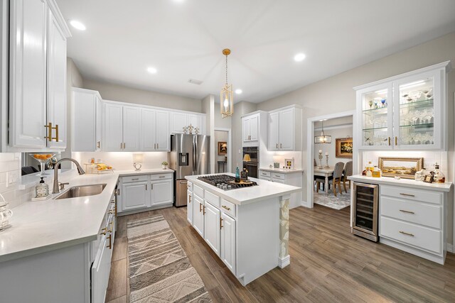 kitchen featuring white cabinets, appliances with stainless steel finishes, a sink, wine cooler, and dark wood-style floors