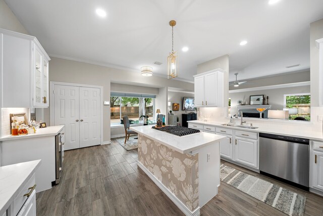 kitchen with stainless steel appliances, ornamental molding, a sink, and white cabinetry