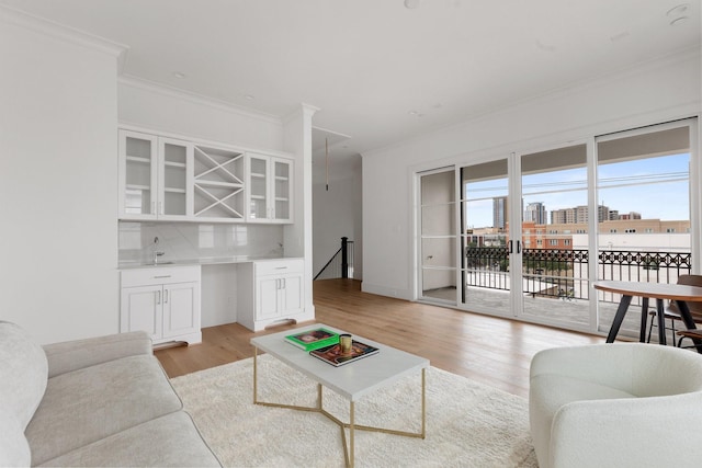 1323 Peden St, Houston, TX 77006 - living room with light wood finished floors, bar area, and crown molding