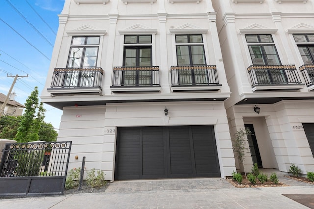 1323 Peden St, Houston, TX 77006 - townhome / multi-family property with an attached garage, fence, a balcony, and french doors