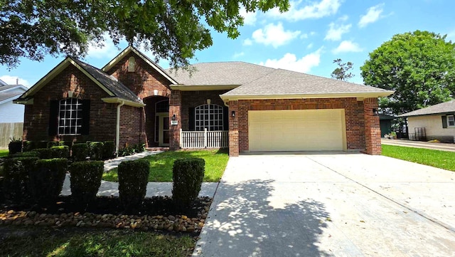view of front facade featuring a garage, brick siding, a front yard, and concrete driveway