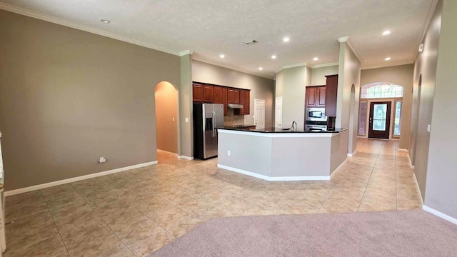 kitchen with recessed lighting, arched walkways, light tile patterned floors, stainless steel appliances, and dark countertops