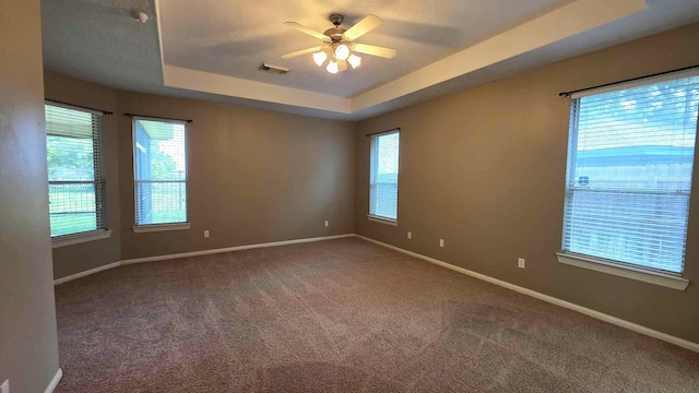 unfurnished room with carpet flooring, visible vents, ceiling fan, and baseboards