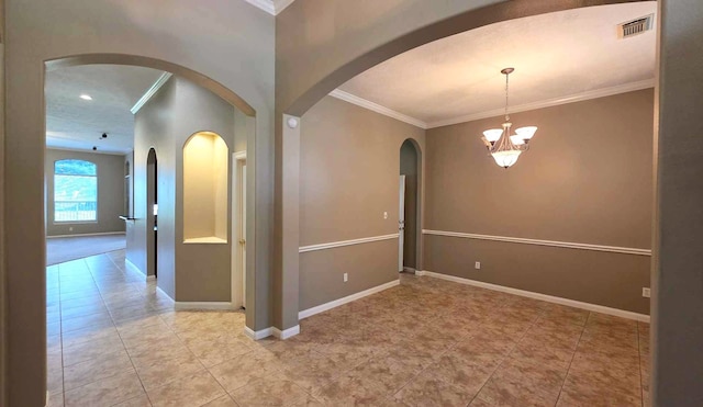 empty room with an inviting chandelier, visible vents, baseboards, ornamental molding, and arched walkways
