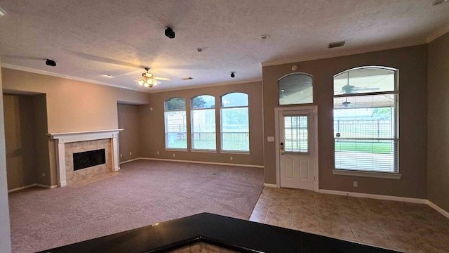 unfurnished living room with ornamental molding, a textured ceiling, ceiling fan, and visible vents