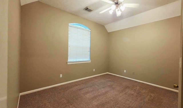 carpeted spare room featuring baseboards, visible vents, a ceiling fan, and vaulted ceiling
