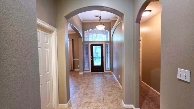 8931 Pine Shores Dr, Humble, TX 77346 - entryway with a textured wall, crown molding, arched walkways, and light tile patterned flooring