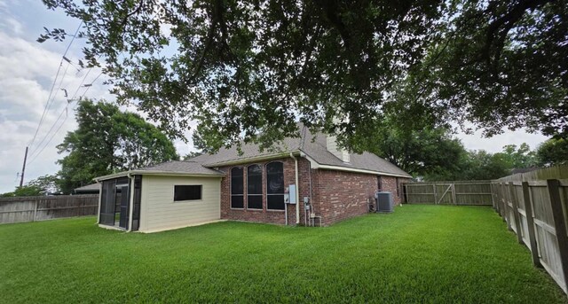 8931 Pine Shores Dr, Humble, TX 77346 - back of property with a sunroom, brick siding, and central air condition unit