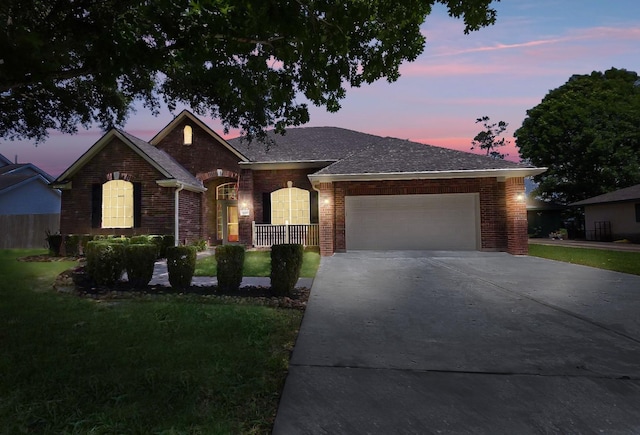 8931 Pine Shores Dr, Humble, TX 77346 - ranch-style house featuring a garage, a front lawn, driveway, brick siding, and roof with shingles