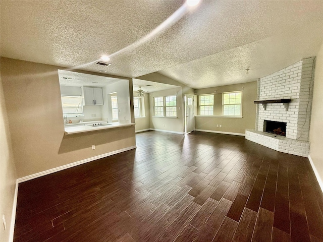 8818 Fern Valley Dr, Houston, TX 77044 - unfurnished living room with dark wood finished floors, a textured ceiling, baseboards, ceiling fan, and a brick fireplace